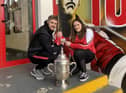 Derry City striker Jamie McGonigle holds master Jamie Mark McGrath alongside mammy Caoimhe McCallion pictured beside the FAI Cup trophy.