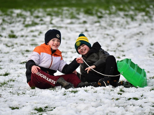 Children enjoy a day off school and a slide in the snow in Brooke Park on Thursday afternoon. Photo: George Sweeney