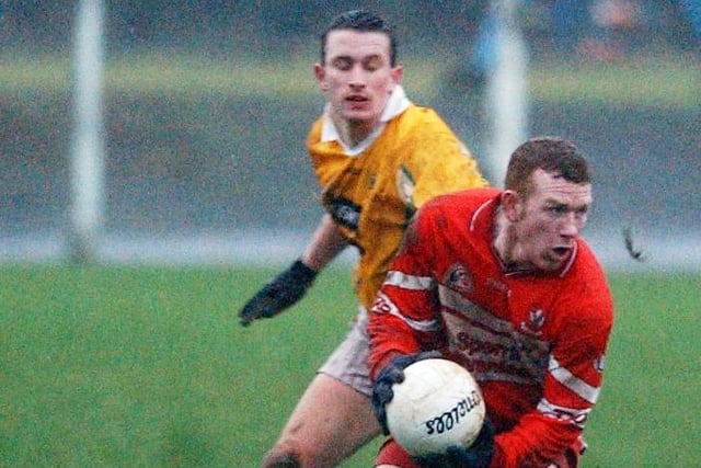 Derry's Fergal Doherty gets his pass away despite pressure from Antrim during the McKenna Cup clash at Glen in January 2004.