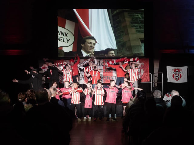 Local children from Holy Child Primary School and Nursery Unit pictured joining the cast for the final scene on Tuesday night. A 'young' Liam Coyle looks out from the screen. (Photo: Jim McCafferty)