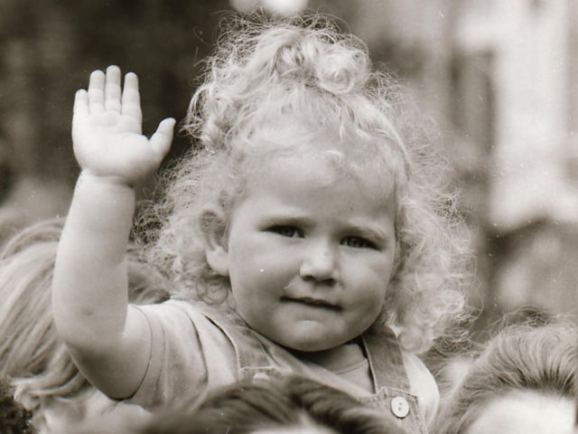 A young fan waves to the cameraman.