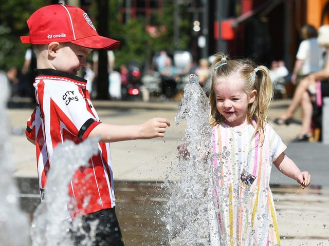 Pearse and Orlaith Sparkes enjoy cooling down in the fountains at Guildhall Square.