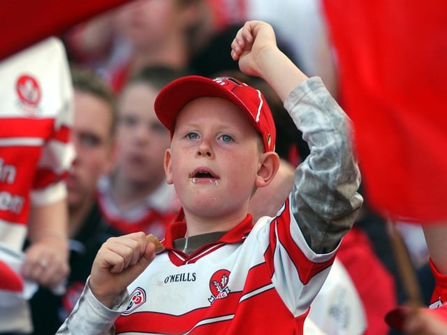 This young lad took a break from his lunch to cheer the arrival of his favourite team. (3108A33)