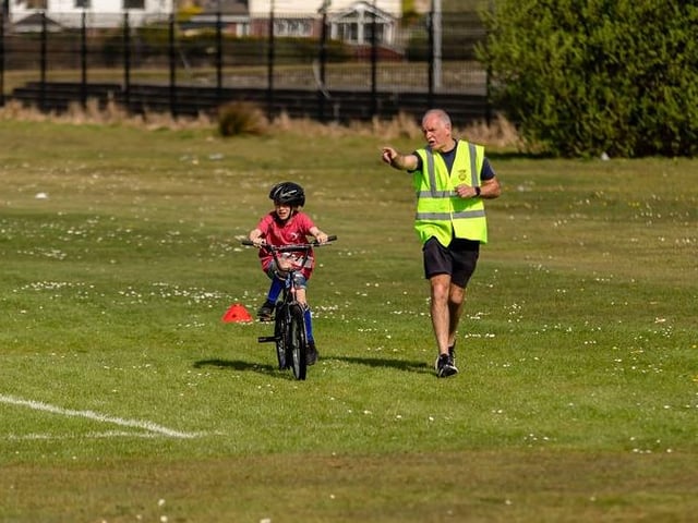 George Harkin helps out a young cyclist during the Caina Healey Children's Try-a-Tri at Templemore Sports Complex. (Photo: Michelle Camlbell)