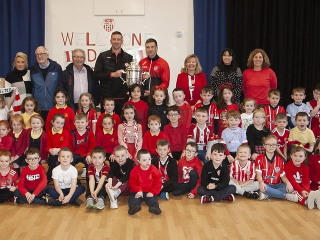 Steelstown Primary School Primary 2 pupils pictured with Shane and Patrick McEleney, the FAI Cup and staff, past and present. (Photo: Jim McCafferty)