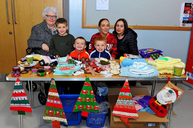 Ann McKeever (left) with Jane Breslin, Kayleigh Breslin, Cael, Quinn and Lenny at her stall at the Christmas Craft Fair held in the Galliagh Community Centre on Saturday afternoon. Photo: George Sweeney. DER2250GS – 74