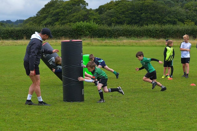 Participants at the recent City of Derry Youth Rugby Summer Camp practise tackling with City of Derry senior player CJ Cregan.  Photo: George Sweeney. DER2331GS – 58