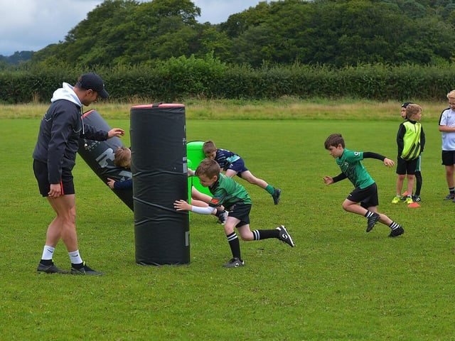 Participants at the recent City of Derry Youth Rugby Summer Camp practise tackling with City of Derry senior player CJ Cregan. Photo: George Sweeney. DER2331GS – 58