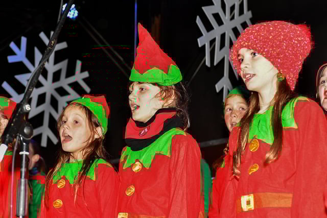 Pupils from Hollybush School Choir singing at the Elf Parade and Christmas Lights switch on at the Community Hub on Friday night. Photo: George Sweeney