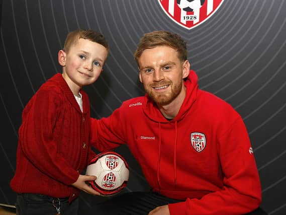 Candystripes fan Eoin Higgins pictured with Derry City's Rob Slevin at the club's merchandise store in Foyleside Shopping Centre. Photo: George Sweeney