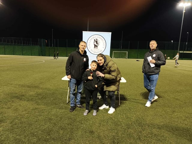 Young Harry Fletcher with Ruaidhrí Higgins collecting the participation trophy for Jonny's 11.