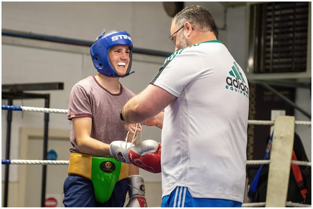 Kevin Duffy shares a joke with this young boxer as he prepares his gloves ahead of a sparring session.