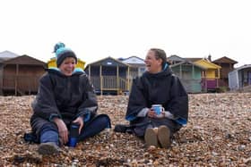 Two friends, wearing coats, have a conversation