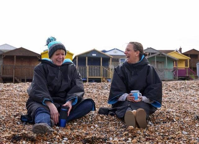 Two friends, wearing coats, have a conversation