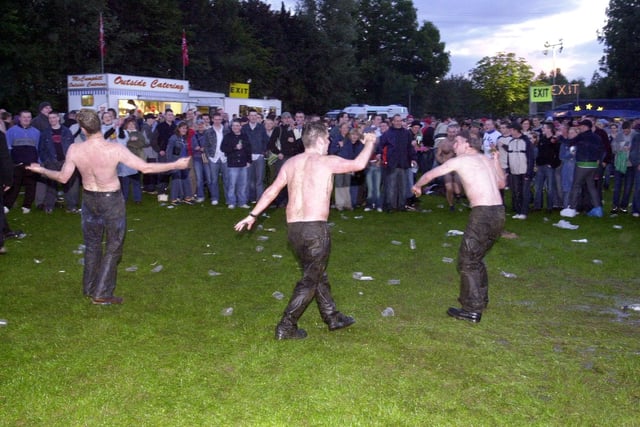 These Oasis and Ocean Colour Scene fans were undeterred by the rain during the concert in September 2002.
