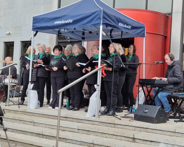 CALMS' community choir, Thyme To Sing performing on the steps of the Council offices as part of the Foyle Maritime Festival's Beyond Blue.