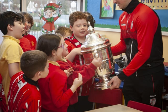 Derry City star Patrick McEleney lets the pupils hold the FAI Cup at Steelstown PS. (Photo: Jim McCafferty)