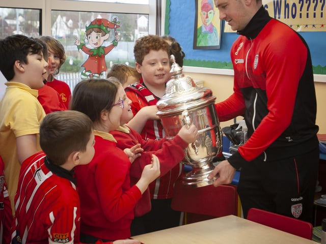 Derry City star Patrick McEleney lets the pupils hold the FAI Cup at Steelstown PS. (Photo: Jim McCafferty)