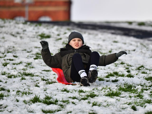 Children enjoy a day off school and a slide in the snow in Brooke Park on Thursday afternoon. Photo: George Sweeney