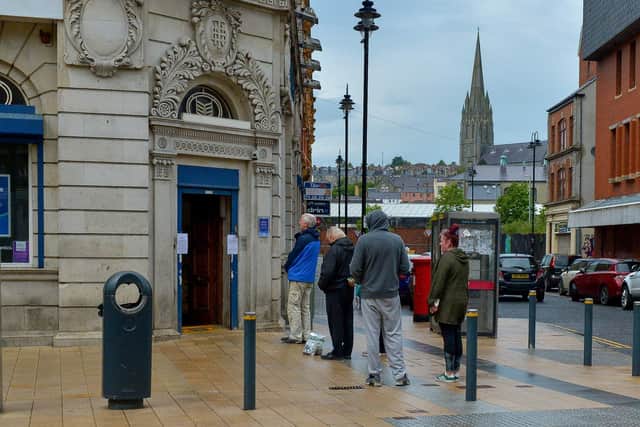 People queue outside the Bank of Ireland, on Strand Road, when businesses reopened in the city centre last weekend. DER2420GS – 024