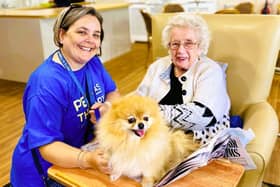 A Pets As Therapy volunteer bringing their dog to their local care home to spend time with residents