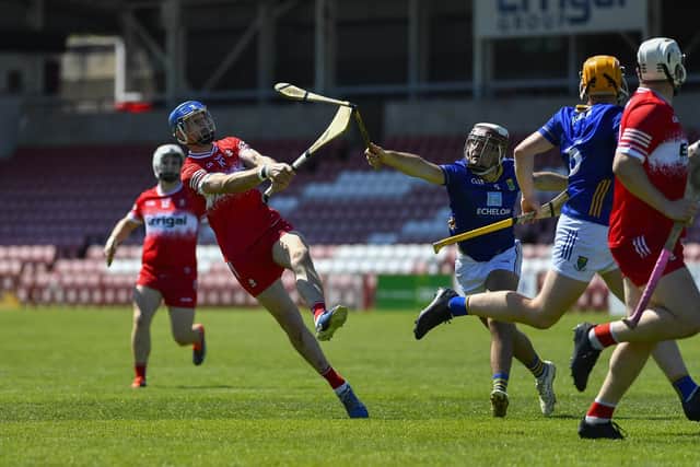 Derry’s Thomas Brady gets off a shot despite a challenge from Wicklow’s John Toomey.  Photo: George Sweeney