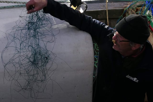 Skipper Liam O'Brien displays the amount of monofilament netting that was wrapped around the seal's neck and flipper, digging into its neck and making the flipper immobile.