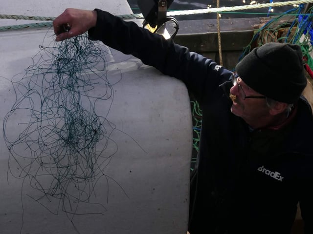 Skipper Liam O'Brien displays the amount of monofilament netting that was wrapped around the seal's neck and flipper, digging into its neck and making the flipper immobile.