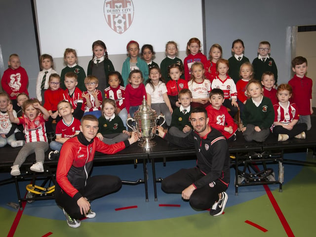 Derry players Caoimhin Porter and Michael Duffy and the FAI Cup pictured with the P1 classes at Greenhaw PS.