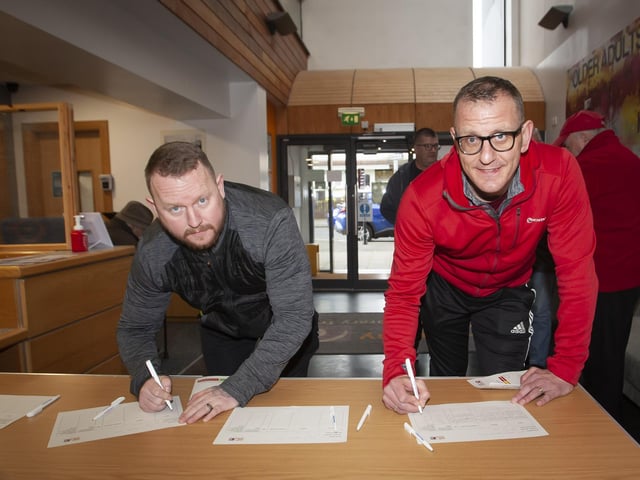 SIGNING IN!. .. . . .The first two through the door signing in for the Men’s Health Day at the Old Library Trust, Creggan on Saturday last, as part of International Men’s Day were Sean Harris and Denis McLaughlin. (Photos: Jim McCafferty Photography)