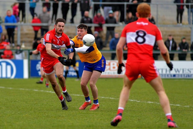 Under pressure Chrisse McKaigue gets off a pass to Conor Glass during Sunday’s game against Clare in Owenbeg. Photo: George Sweeney. DER2312GS – 09
