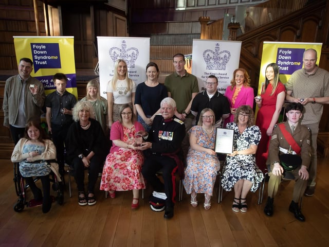 The Vice Lord Lieutenant Alan Moore, OBE, presenting the King's Award for Voluntary Service and badges to volunteers and directors at last week's awards ceremony in the Guildhall, Derry.