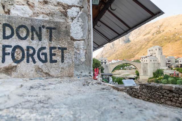 View of Don't Forget sign and old bridge on August 10, 2012 in Mostar, Bosnia.