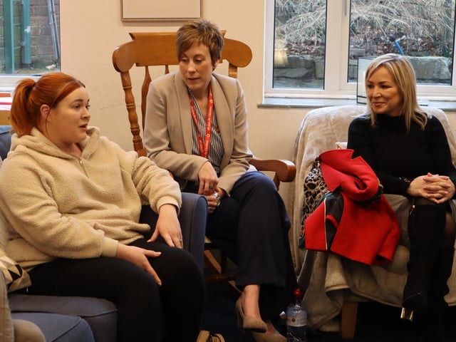 First Minister Michelle O’Neill sits beside Ruth-Ann Delija from Action for Children and listens to local parent Natasha McLaughlin, whose daughter attends Sure Start.