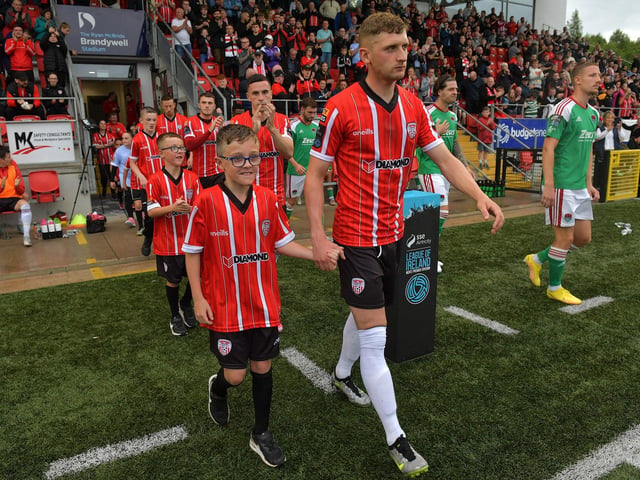 Derry City players and mascots make their way onto the pitch at the Brandywell Stadium on Friday evening. Photograph: George Sweeney. DER2325GS – 95