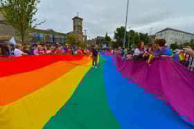 Preparing the rainbow flag for the Foyle Pride parade in Derry at a previous parade. Photograph: George Sweeney / Derry Journal. DER2234GS – 025