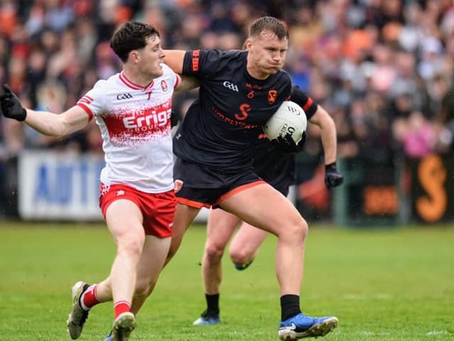 Derry's Padraig McGrogan tries to stop Rian O'Neill during Saturday's All Ireland Group 4 clash at the Athletic Grounds.