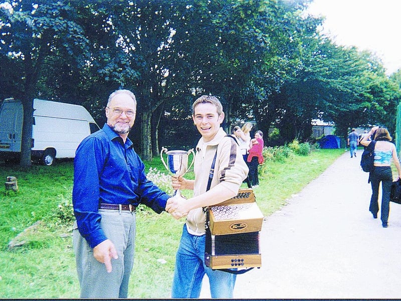 Daire Mulhern, grandson of Davy and Peggy Fahy, from Francis Street, Derry, pictured being congratulated by his teacher, Martin Connolly, after he won the Under-18 All-Ireland Button Accordion competition at the Fleadh Ceoil na hÉireann in Listowel, Co. Kerry.