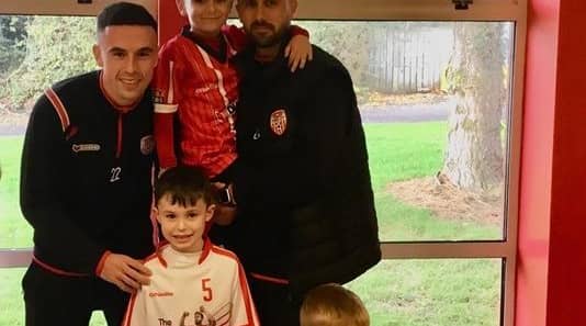 Derry City players Daniel Lafferty with his son and Jordan Mc Eneff with his nephew who both attend St. John’s Primary school.