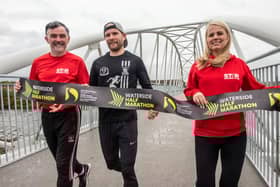 Waterside Half Marathon reigning senior men’s champion Kyle Doherty from City of Derry Spartans promoting the event on the Pennyburn Footbridge with Star Running Club members Patrick McCarry and Louise Wilkinson.