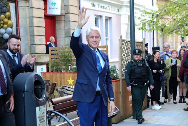 Bill Clinton waves to the public in Guildhall Street