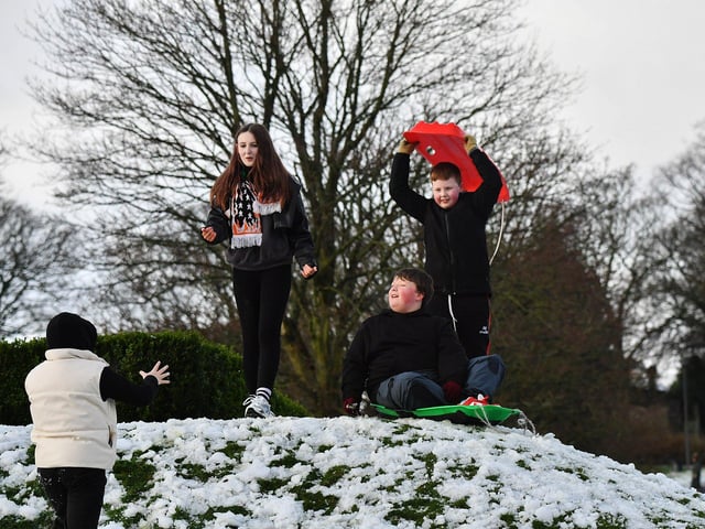 Children enjoy a day off school and a slide in the snow in Brooke Park on Thursday afternoon. Photo: George Sweeney