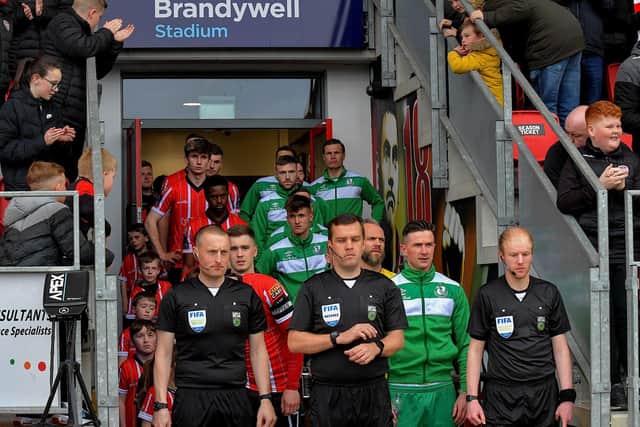 Match referee Robert Harvey leads out the Derry City and Shamrock Rovers teams for Monday evening’s big game at the Brandywell where the champions came out on top Photo: George Sweeney. DER2318GS – 37