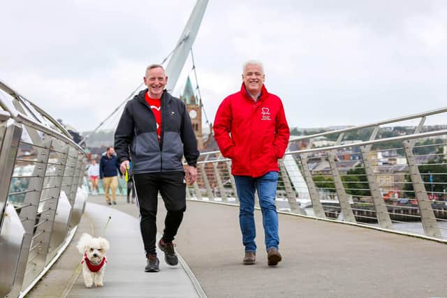 Alex Magee from Derry is taking on a one million step challenge for British Heart Foundation NI. The 46-year-old University lecturer suffered 2 cardiac arrests and is now walking the equivalent distance of the length and breadth of Ireland, approximately 470 miles during July and August to raise funds for BHF NI and is encouraging people in the local community to join him. Pictured with Alex is his 1 year old walking partner, his Bichon Frise Alfie and Fearghal McKinney, head of BHF NI.
