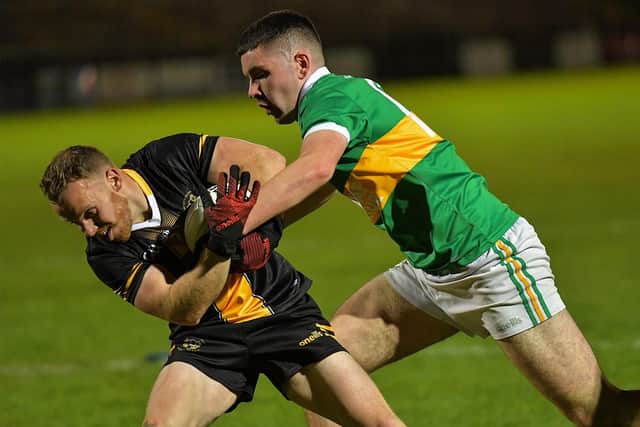 Ballymaguigan ‘s Pearce O’Neil grapples with Moneymore’s Mark Bell during the Junior Football Championship final at Owenbeg on Saturday evening.  Photo: George Sweeney