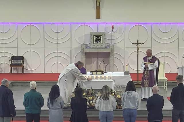 Members of the eight victims’ families brought memorial candles to the altar as their names were read aloud.