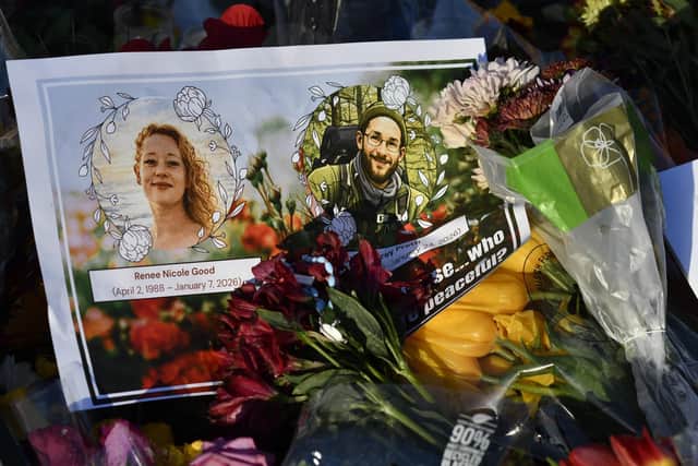A card with images of Renée Good and Alex Pretti lies among flowers and other mementos at a memorial in Minneapolis, Minnesota, on January 27, 2026. (Photo by Octavio JONES / AFP via Getty Images)