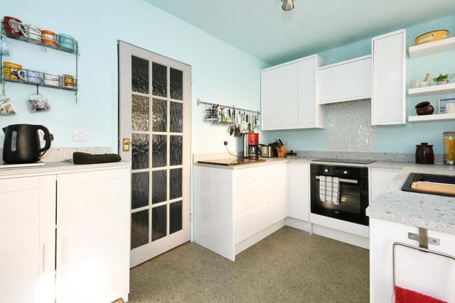 The fully fitted kitchen features a range of integrated appliances, including an electric hob and oven with cooker-hood over, dishwasher and fridge freezer.