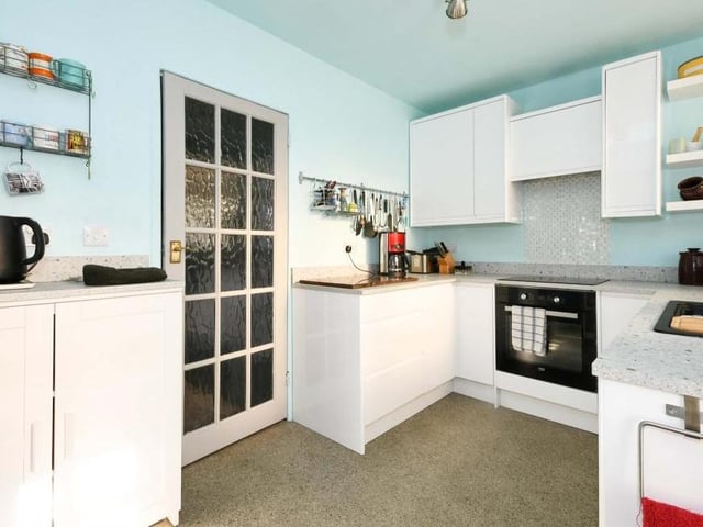 The fully fitted kitchen features a range of integrated appliances, including an electric hob and oven with cooker-hood over, dishwasher and fridge freezer.