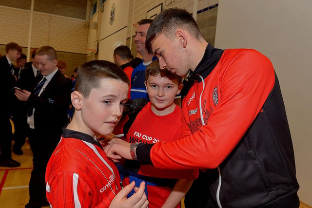 Derry Citys Liam Mullan signs autographs for pupils  during a visit to the school, with the FAI Cup, on Monday . Photo: George Sweeney. DER2247GS  29